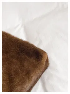 Braune Plüschtasche Textur Nahaufnahme, weiches Fellgewebe Detail, minimalistischer Hintergrund.
