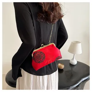 Detail view of vintage Chinese style red black embroidered evening bag with metal clasp and chain.