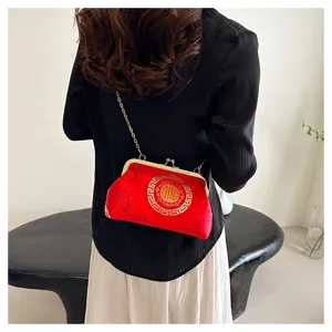 Detail shot of red Chinese style evening bag with gold embroidery, chain strap and lock.