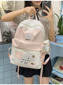 Primer plano de la hermosa mochila rosa de lunares con bordado de gato y osito de peluche.
