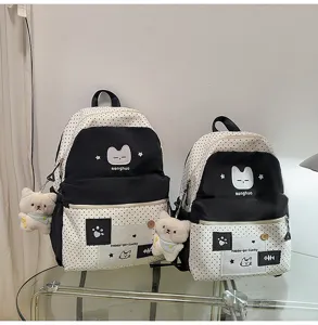 Detalle de la linda mochila de lunares con colgante de peluche y bonito bordado de gato.