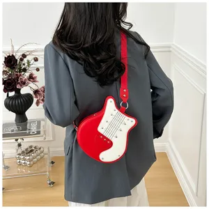 Guitar shaped crossbody bag detail showcasing red white contrast, metal studs and red strap.