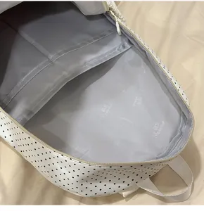Linda mochila escolar blanca con lunares de gran capacidad y estilo casual para estudiantes.