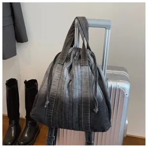 Vue détaillée du sac à dos cordon en denim vintage lavé, cartable multifonctionnel décontracté.