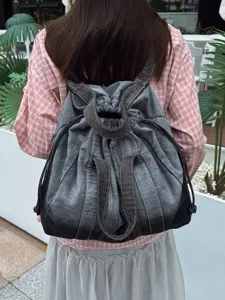 Sac à dos en denim délavé vintage avec cordon de serrage pour voyage décontracté.