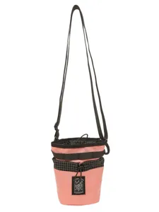 Borsa a tracolla a secchiello neutra e alla moda con motivo a quadri rosa e neri.