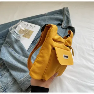 Detailaufnahme der gelben Freizeittasche aus Nylon mit mehreren Taschen und Reißverschluss.