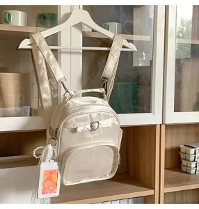 Harajuku style minimalist beige crossbody backpack with cute heart buckle and mesh pocket detail.