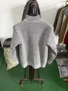 Vue détaillée d'un pull en tricot gris pour homme avec col montant et belle texture.