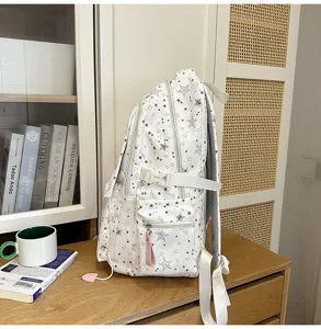 Vue latérale détaillée d'un sac à dos d'étudiant blanc élégant avec des motifs d'étoiles.