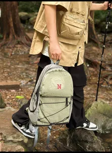 Detailansicht des Outdoor-Wanderrucksacks, leichtes grünes Kordelzug-Design mit rotem Logo.