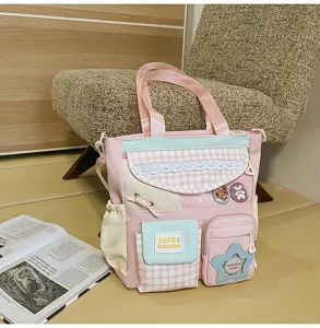 Λεπτομέρεια της χαριτωμένης τσάντας shopper color-block με μπροστινές τσέπες και σήματα.