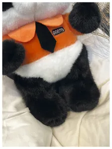 Detailaufnahme des süßen Panda Plüsch Kinderrucksacks im schwarz-orangen Design.