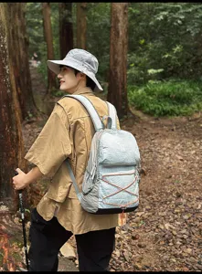 Nahaufnahme des leichten Outdoor-Wanderrucksacks mit Kordelzug in waldreicher Szene.