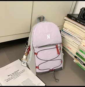 Detailansicht des modischen lila-grauen Freizeitrucksacks mit Kordelzug und Anhänger.