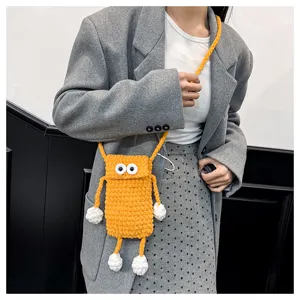 Detailed view of handmade knitted cute big eye phone crossbody bag worn by model.