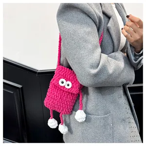 Handmade crochet knit phone bag detail, cute big eyes and dangling limbs crossbody.