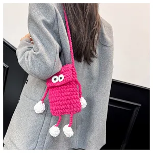 Cute handmade chunky knit crossbody phone bag with funny big eyes and playful dangling limbs.