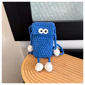Handmade blue crochet phone bag with cute big eyes, perfect detail shot for daily commuting.