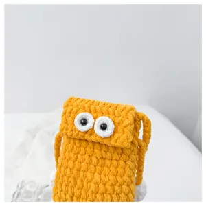 Handmade knit big eyes phone bag detail shot, cute yellow crochet crossbody shoulder bag for women.