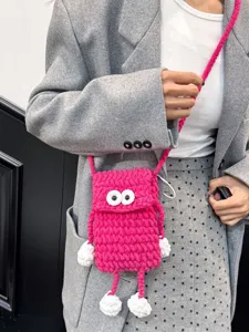Cute handmade crochet phone bag with big eyes and chunky knit crossbody strap for women.