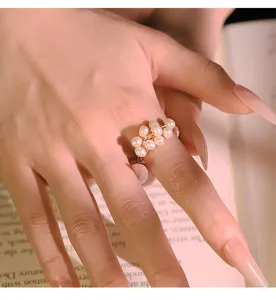 Detailed close-up of the delicate handmade freshwater pearl wire-wrapped ring worn on hand.