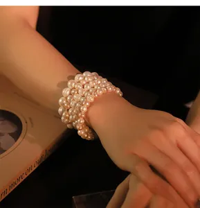 Detailaufnahme eines mehrsträngigen Naturperlen-Armbands, schickes Lagen-Design, elegant.