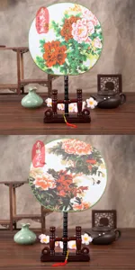Detailed view of traditional Chinese circular fan with peony pattern and wooden display stand.