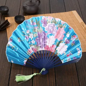 Chinese style folding fan with blue floral fabric pattern and green tassel for summer women.