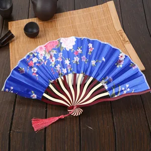 Traditional Chinese folding silk fan with floral pattern, bamboo ribs and red tassel decor.