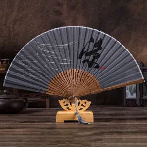 Detailed view of traditional Chinese folding fan with linen fabric surface and wooden frame on a stand.