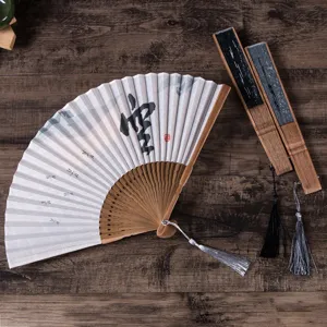 Exquisite Chinese folding fan detail showing linen surface with calligraphy art and elegant tassels.