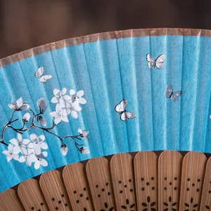 Close-up view of Japanese style folding fan with blue floral and butterfly print details.