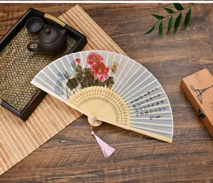 Traditional Chinese folding fan with floral art and tassel, ideal for summer and dance.