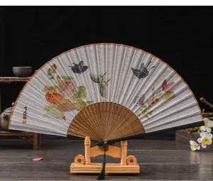 Detailed close-up of traditional Chinese linen folding fan with bamboo ribs and elegant tassel.