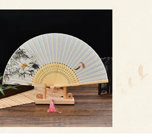 Detail view of a traditional Chinese folding fan with lotus pattern and wooden ribs, elegant style.