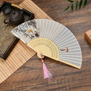 Exquisite Chinese folding fan with delicate bamboo ribs and lotus painting for summer.