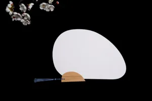 Détail d'éventail en papier DIY, surface de ventilateur blanche avec manche en bambou et gland.