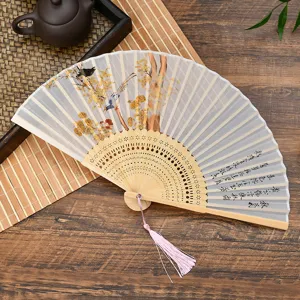 Chinese antique folding fan with delicate silk fabric, bamboo frame and elegant pink tassel.