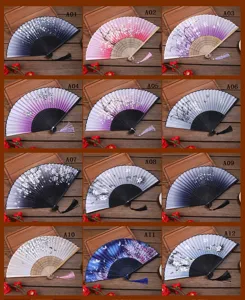 Éventails pliants traditionnels chinois à motifs floraux, monture en bois et pompons.
