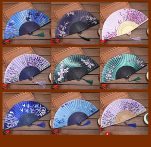 Detailed view of Chinese style silk folding fan with elegant floral print and tassel pendant.