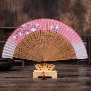 Traditional folding hand fan with cherry blossom pattern, pink gradient silk and wooden ribs.
