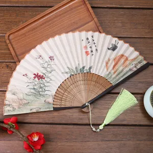 Traditional Chinese folding fan with linen fabric surface, wooden ribs and tassel.