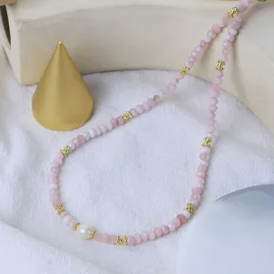 Nahaufnahme der exquisiten rosa Perlenkette mit goldenen Abstandshaltern und Perle.