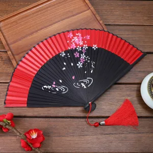Antique Chinese folding fan with cherry blossom pattern and tassel for dance or photo props.