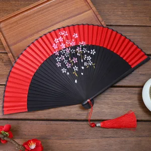Detailed view of traditional Chinese Hanfu folding fan with cherry blossoms and red tassel.