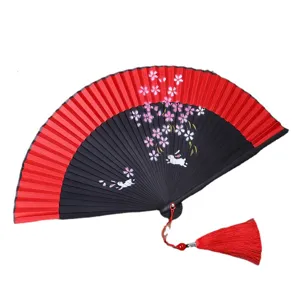 Traditional Japanese folding fan with red black design cherry blossom rabbit print and red tassel.