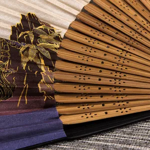 Chinese style folding silk fan with bamboo ribs and traditional print, detailed view.