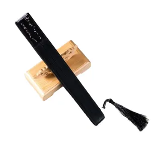 Black folding hand fan with wooden display stand and tassel, Japanese style vintage accessory.