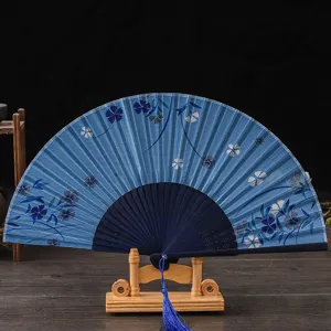 Japanese style folding fan with blue floral pattern, traditional dance photography prop.